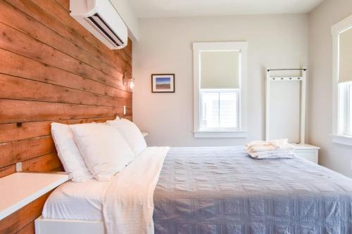 um quarto com uma cama e uma parede de madeira em Modern, Private Patio, Walk to Town! em Provincetown