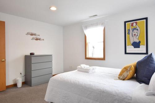 a bedroom with a white bed and a window at 12216 - Beautiful Views of Cape Cod Bay Access to Private Beach Easy Access to P-Town in Truro