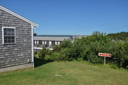 a yard next to a house with a street sign at 12216 - Beautiful Views of Cape Cod Bay Access to Private Beach Easy Access to P-Town in Truro