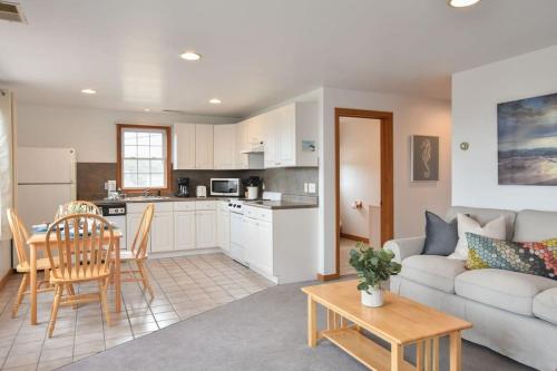ein Wohnzimmer mit Couch und Tisch und eine Küche in der Unterkunft 12218 - Beautiful Views of Cape Cod Bay Access to Private Beach Easy Access to P-Town in Truro