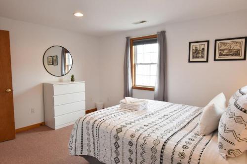 a white bedroom with a bed and a mirror at 12215 - Beautiful Views of Cape Cod Bay Access to Private Beach Easy Access to P-Town in Truro