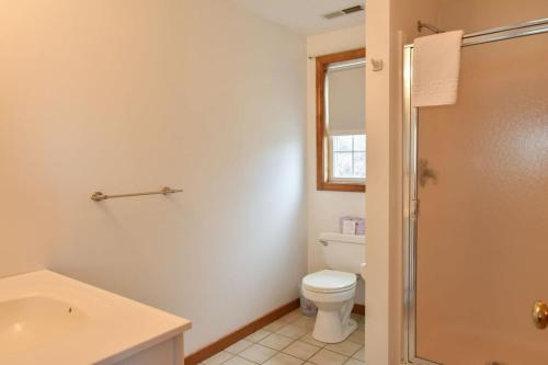 a white bathroom with a toilet and a sink at 12215 - Beautiful Views of Cape Cod Bay Access to Private Beach Easy Access to P-Town in Truro