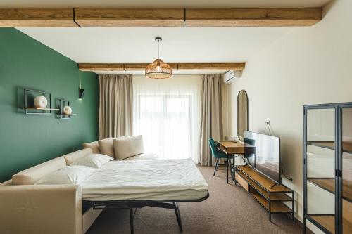 uma sala de estar com uma cama e um sofá em Stokker Hotel em Oradea