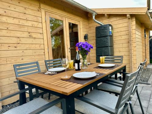 a wooden table with chairs and a bottle of wine at Chalet Lasserg in Münstermaifeld