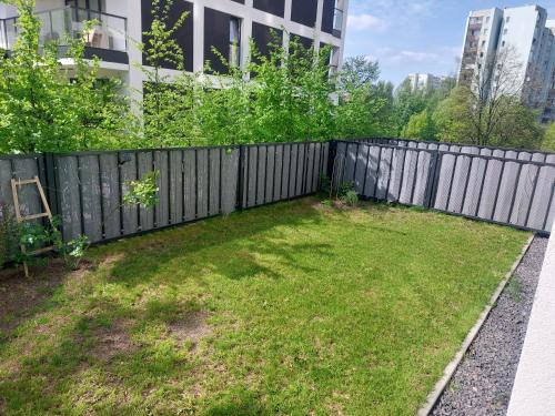 a backyard with a fence and a grass yard at Słońce Bemowa in Warsaw