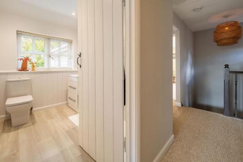 uma casa de banho com um WC e uma janela em Foxhole Cottage 6 em Stowmarket