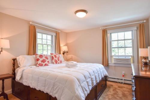 a bedroom with a large bed and two windows at Private Patio Walk to Commercial St in Provincetown