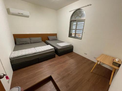 Habitación pequeña con 2 camas y ventana en Lanyu Yishanan B&B, en Lanyu