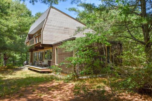 a small house with a porch in the woods at Architectural modern home 5 mins to beach in Truro