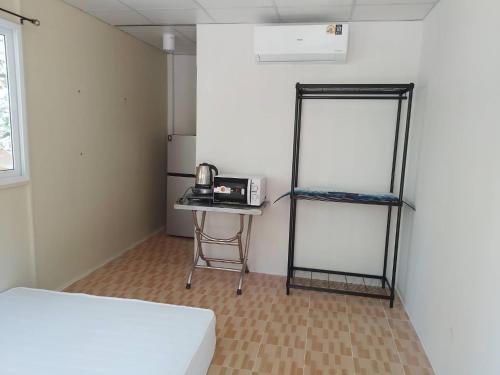 a room with a bed and a table with a microwave at บ้านรัญจวนสาขาสมุย in Ban Ko Khwan