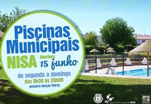a sign in the grass next to a swimming pool at Casa da Aldeia by Portus Alacer in Arez