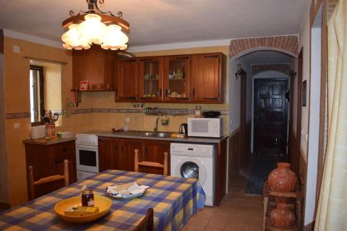 a kitchen with a table and a sink and a stove at Casa da Aldeia by Portus Alacer in Arez