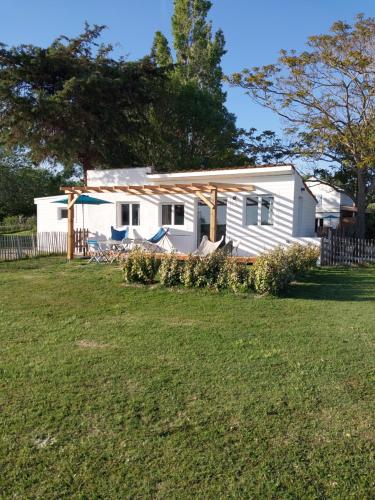 a small white house in a field with a yard at Mas Constantin in Salin-de-Giraud