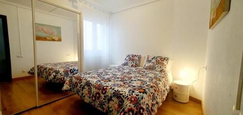 Dormitorio pequeño con cama y espejo en Oviedo 2+2, en Oviedo