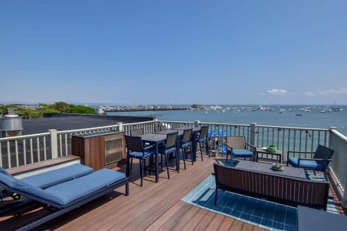 una terraza con sillas y mesas y vistas al agua en Renovated Oceanfront Penthouse, en Provincetown