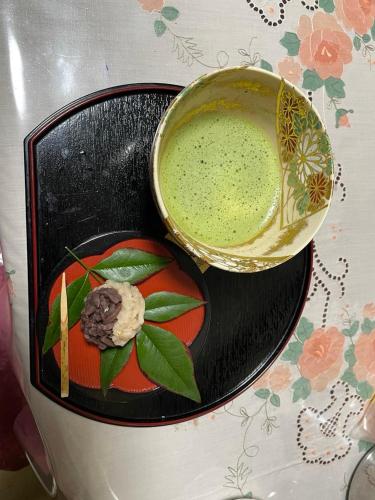 a bowl of green liquid next to a plate of food at Kyoto Wakouan Retro Stay in Kinugasa