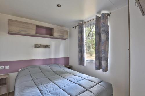 a bedroom with a bed and a window at Camping L'Etang D'Ardy *** in Saint-Paul-lès-Dax