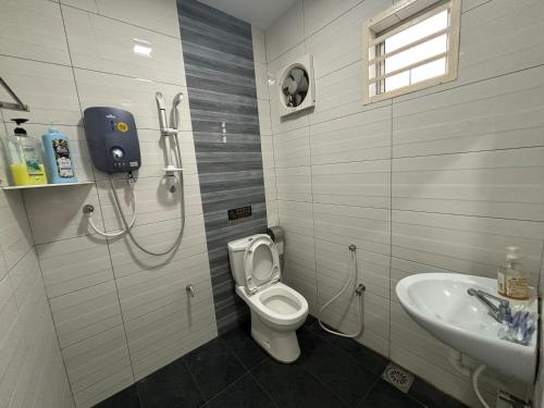 uma casa de banho com um chuveiro, um WC e um lavatório. em 126 Homestay TYPE A em Tangkak
