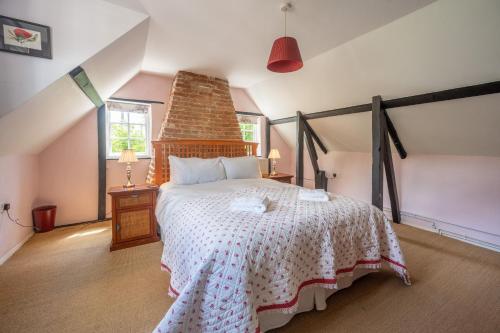 a bedroom with a large bed in a attic at Peak Hill Cottage 4 in Theberton