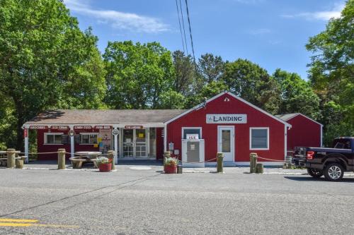 a red building with a garage with a truck parked in front at Fish or boat directly off our shared dock in Eastham