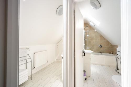 an attic bathroom with a sink and a tub at Peak Hill Cottage 4 in Theberton