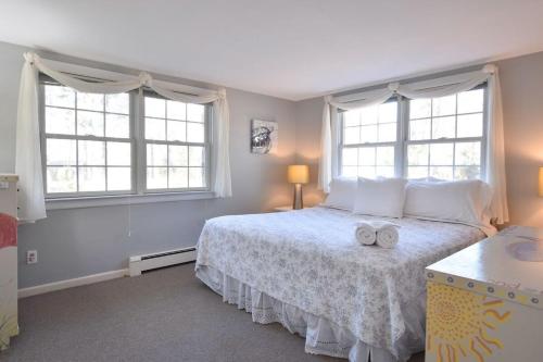a bedroom with a bed with two towels on it at Peace and Quiet & Spacious Back Deck in Wellfleet