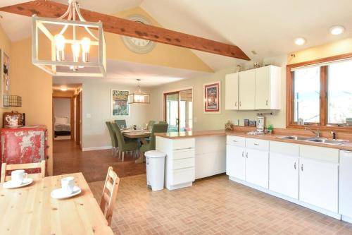 a kitchen with white cabinets and a table and a dining room at 14443 - Expansive Home Abutting Rail Trail Near First Encounter and Hatch Beaches in Eastham