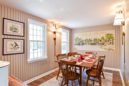 a dining room with a wooden table and chairs at Marsh Front Home w Sweeping Views in Wellfleet