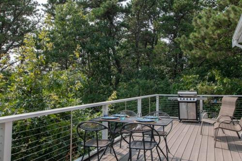 a patio with a table and chairs on a deck at Marsh Front Home w Sweeping Views in Wellfleet