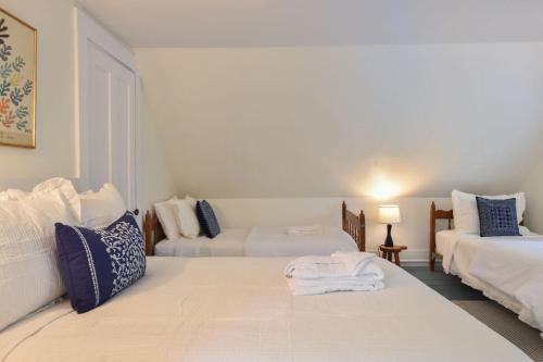 a white room with two beds and a couch at Private Downtown Wellfleet Location in Wellfleet