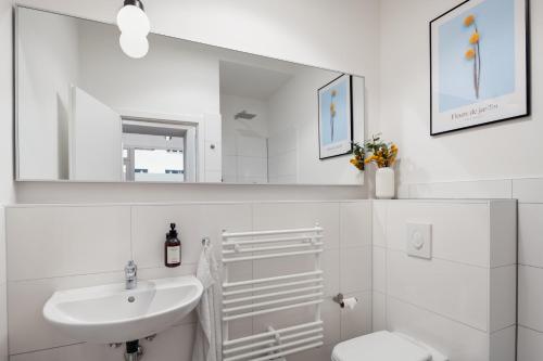 ein Badezimmer mit einem Waschbecken, einem WC und einem Spiegel in der Unterkunft Im Herzen von Kreuzberg - perfekt gelegen für bis zu 8 Personen in Berlin