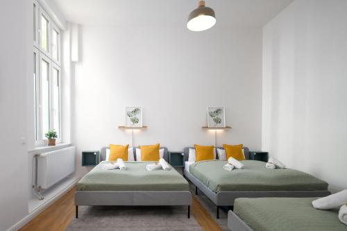 two beds in a room with white walls and windows at Im Herzen von Kreuzberg - perfekt gelegen für bis zu 8 Personen in Berlin