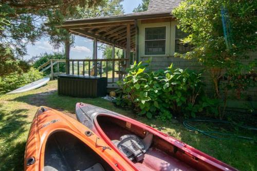 an orange kayak in front of a house at Seaside Retreat w Private Beach Landing in Eastham