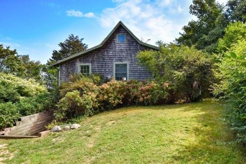 an old house with a garden in front of it at Seaside Retreat w Private Beach Landing in Eastham