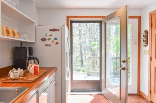 a kitchen with a sliding glass door to a patio at 15 Min Walk to Beach w Kayaks in Wellfleet