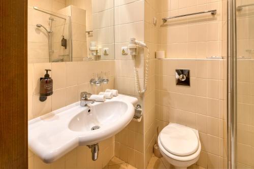 a bathroom with a sink and a toilet at Congress Hotel Centrum in Košice