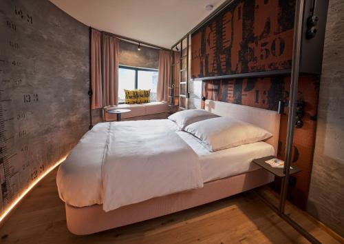 a bedroom with a large bed in a room at John & Will Silo-Hotel by Guldsmeden in Bremen