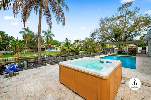uma banheira de hidromassagem num quintal com uma piscina em Bnb Hyperion - 5BR 3BA Home w Pool, Lounge & Deck em Miami