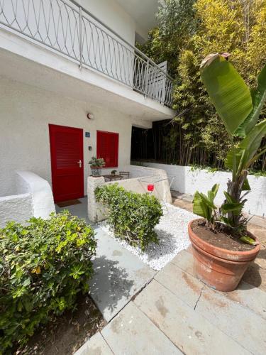 a house with a red door and a plant at Bungalow 97 in Fontane Bianche