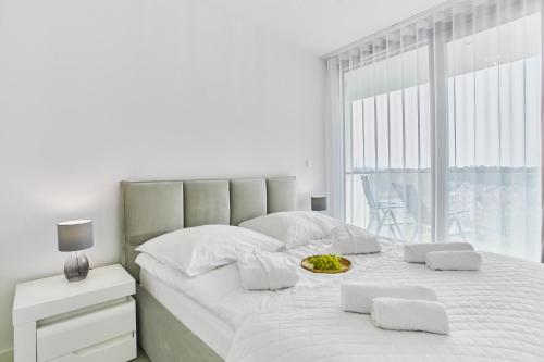 um quarto branco com uma cama grande e uma janela em Wave Private Apartment 6th Floor em Międzyzdroje