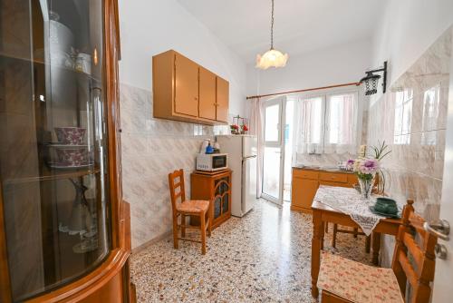 a kitchen with a table and a refrigerator at kleris apartment 3 in Tinos Town