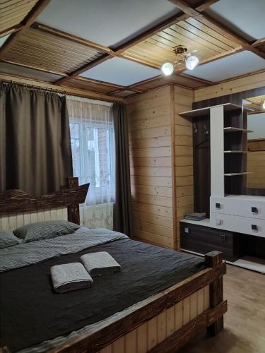 1 dormitorio con 1 cama grande y 2 toallas. en ГІРСЬКІ ПОДОРОЖі en Slavske