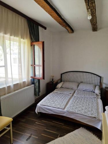 a bedroom with a bed and a window at Domacinska kuca in Bajina Bašta
