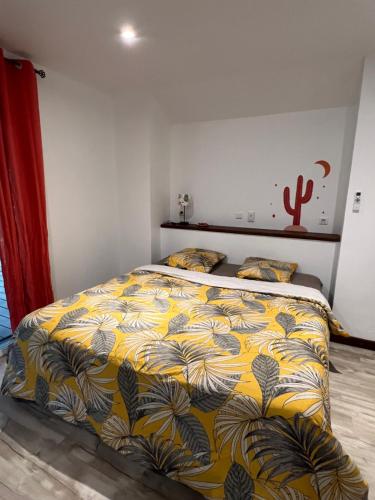 - une chambre avec un lit et une couverture jaune dans l'établissement Bungalow Terra - Sarramea, à Sarraméa