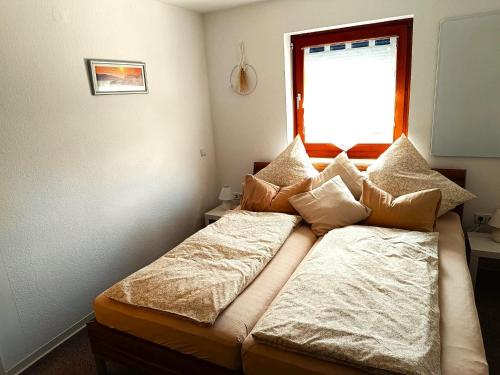 a small bedroom with two beds and a window at Ferienwohnung Schleßmann in Isny im Allgäu