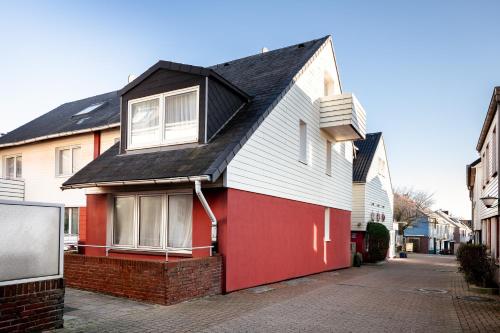 a red and white house with a black roof at Hummerklippen Apartments in Helgoland