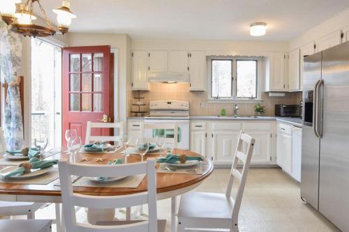 a kitchen with a table and chairs and a refrigerator at Minutes to Oceanside Beaches in Eastham