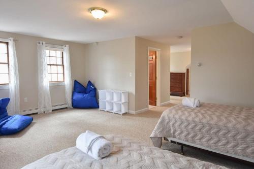 a bedroom with two beds and blue pillows at Minutes to Oceanside Beaches in Eastham