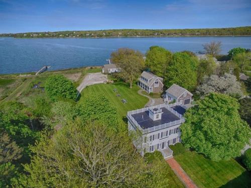 an aerial view of a large house on the shore of a lake at Waterfront Fun at this Huge Family Estate in Eastham