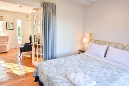 a bedroom with a bed and a chair and a room at Waterfront Fun at this Huge Family Estate in Eastham
